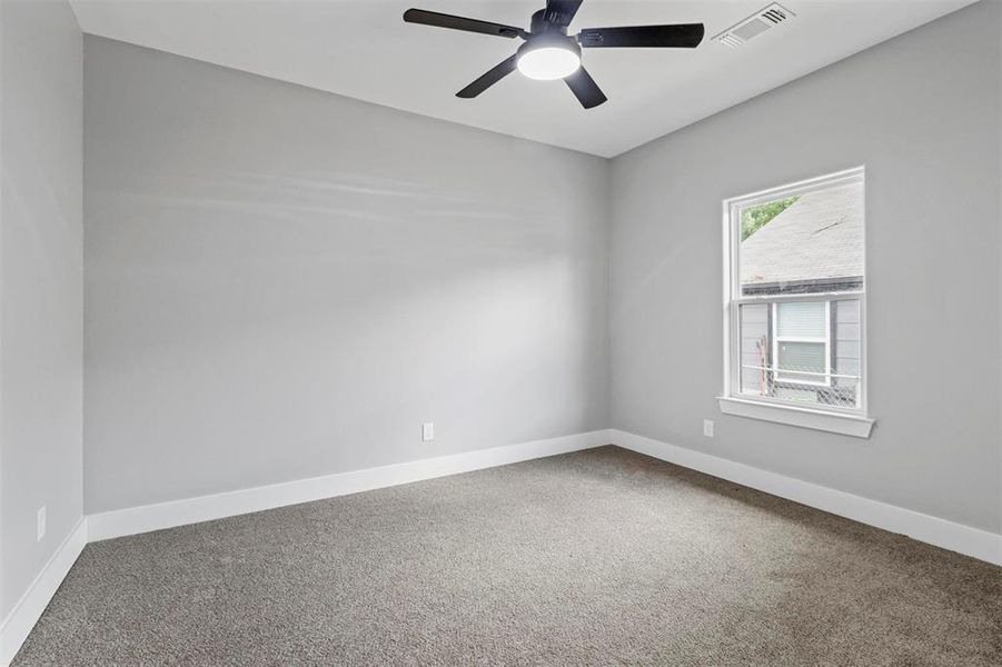 Carpeted empty room featuring ceiling fan