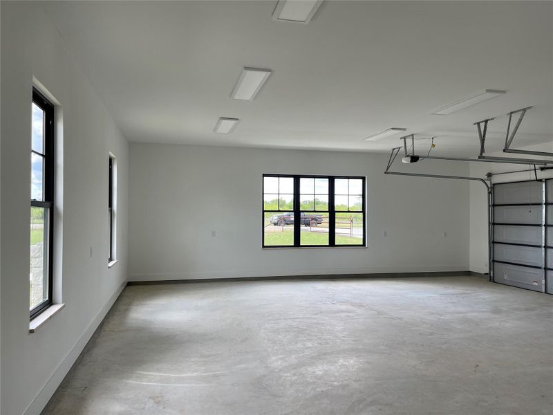Garage featuring a garage door opener and baseboards