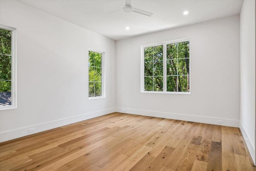 Secondary bedroom, hardwood floors, multi-window views, ceiling fan Secondary bedroom, hardwood floors, multi-window views, ceiling fan