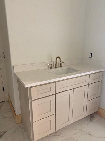 Bathroom with light marble finish flooring and vanity