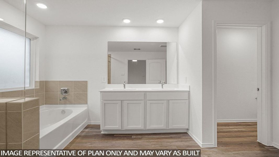 Gorgeous bathroom with a spacious tub, dual sinks with white cabinetry, and hard surface flooring, creating a clean and contemporary feel.