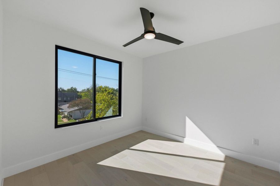 Empty room with light wood-type flooring and ceiling fan