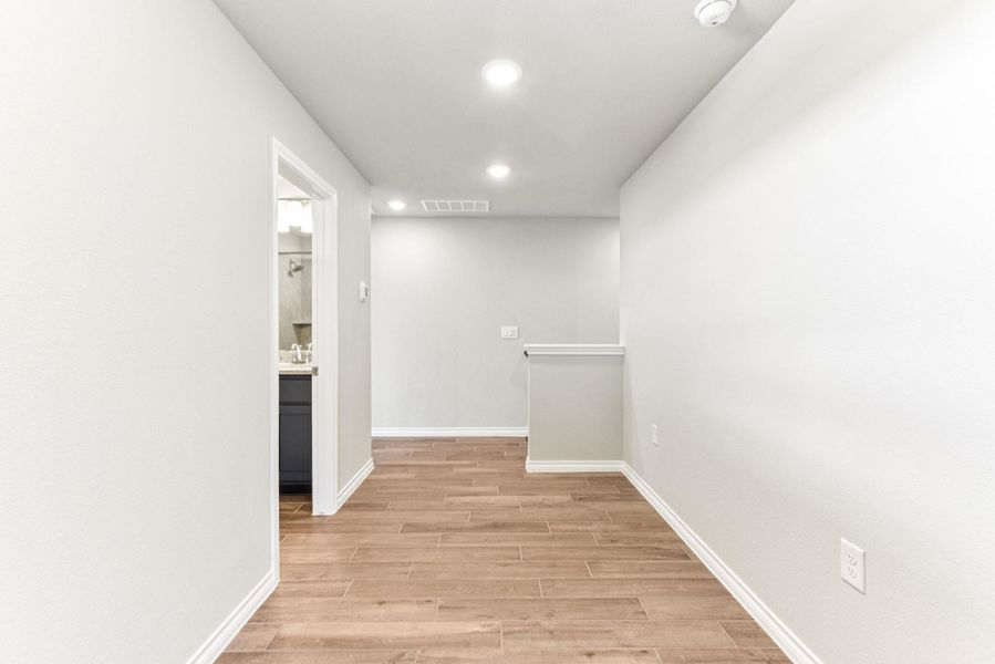 Corridor featuring light wood-style flooring and recessed lighting Corridor featuring light wood-style flooring and recessed lighting