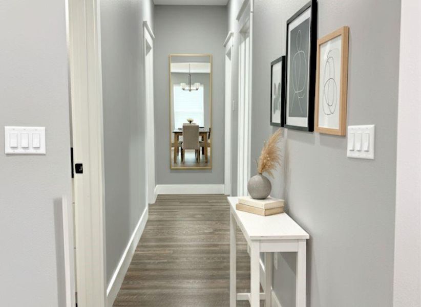 Corridor featuring dark wood finished floors and a chandelier Corridor featuring dark wood finished floors and a chandelier