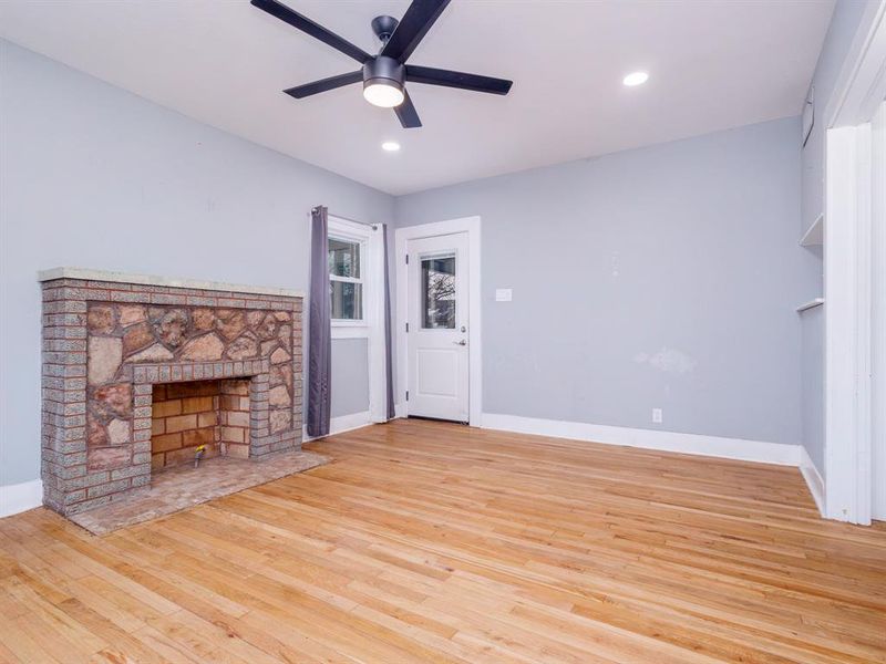 Spacious living room with fireplace equipped with gas jet for a cozy fire on these cool nights.  Check out the beautiful original hardwood floors