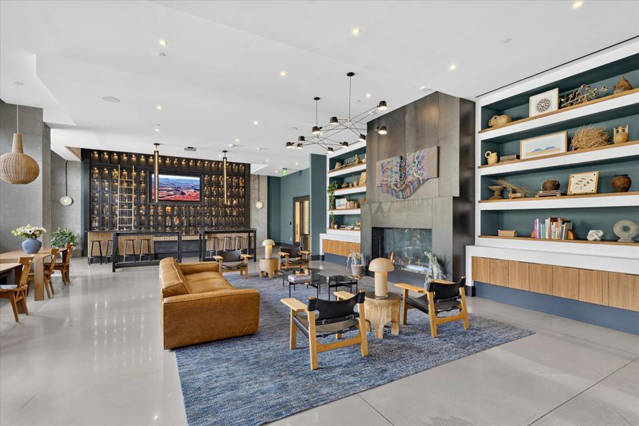 An inviting gathering space features an elegant fireplace, a sophisticated bar area, and contemporary built-in shelving.