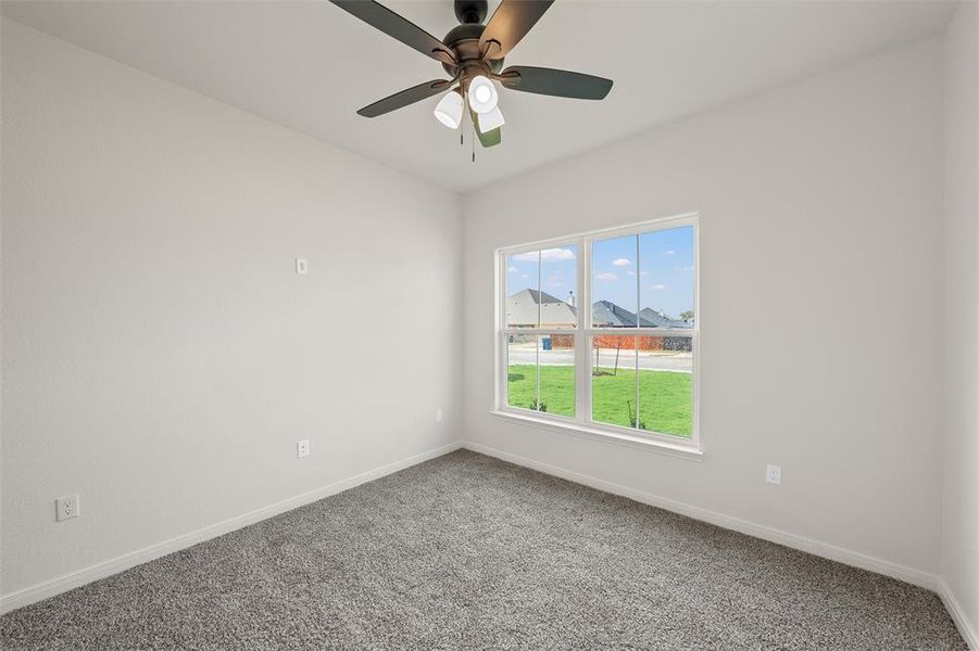 Empty room featuring carpet and a ceiling fan Empty room featuring carpet and a ceiling fan