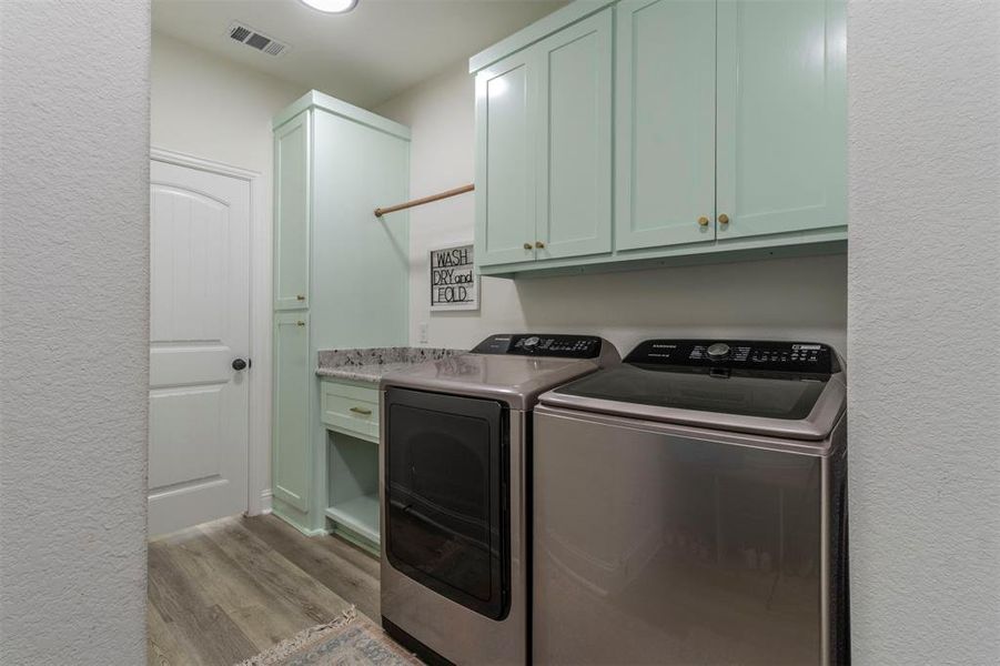 Washroom featuring cabinets, independent washer and dryer, and light hardwood / wood-style floors