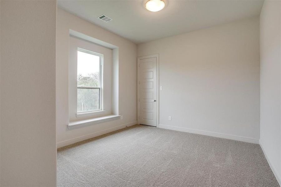 Empty room with light colored carpet