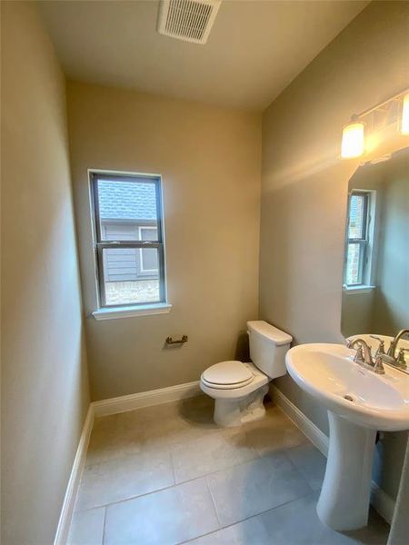 Large powder bath off the entry with pedestal sink, window, and 12x24 tile Large powder bath off the entry with pedestal sink, window, and 12x24 tile
