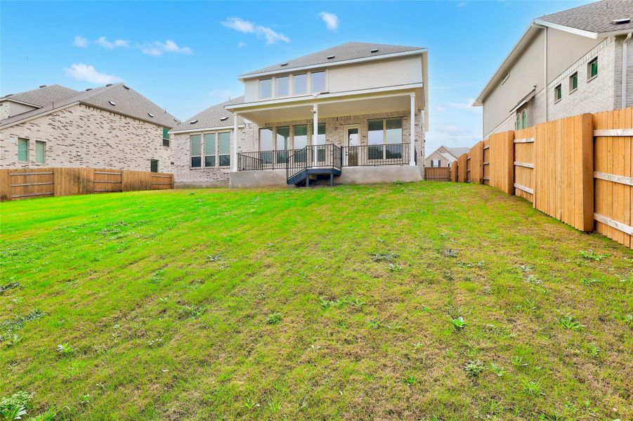 Back of house with a fenced backyard, a patio area, and brick siding