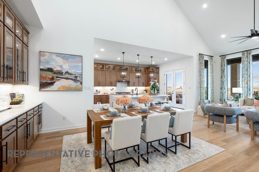Dining space featuring high vaulted ceiling, light wood-style flooring, recessed lighting, baseboards, and ceiling fan