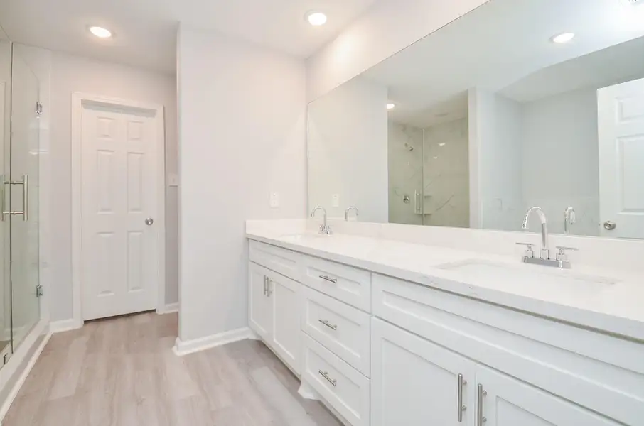 Spa-style bath with dual vanities and a walk-in shower—designed for morning efficiency.