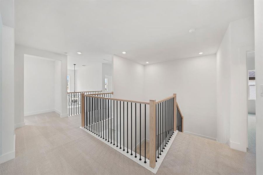 Hallway featuring light carpet, an upstairs landing, and recessed lighting Hallway featuring light carpet, an upstairs landing, and recessed lighting
