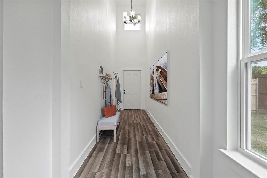 Digitally Staged Corridor with a towering ceiling, plenty of natural light, and dark wood-type flooring