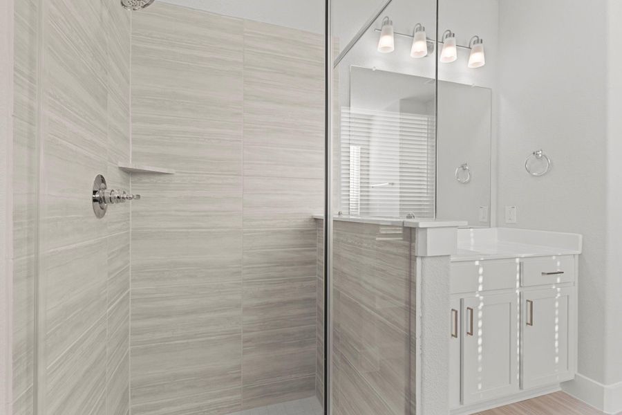 A closer view of the beautifully tiled walk-in shower highlights its clean, modern design and relaxing atmosphere. Sleek fixtures and neutral tile tones add a touch of sophistication to this luxurious primary bath.