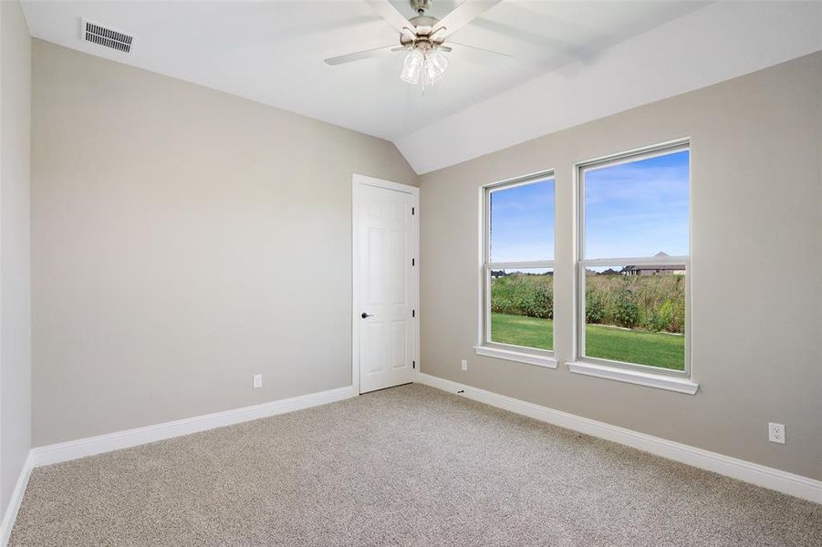 Unfurnished room featuring lofted ceiling, carpet, and ceiling fan