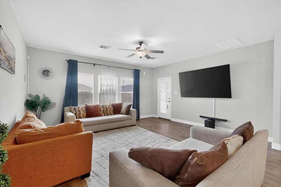 Living area featuring a ceiling fan and wood finished floors Living area featuring a ceiling fan and wood finished floors