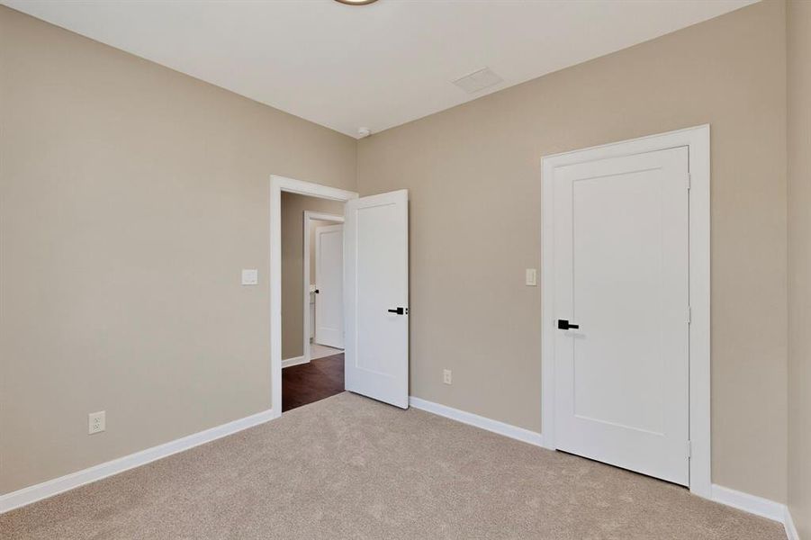 Unfurnished bedroom featuring baseboards and carpet floors Unfurnished bedroom featuring baseboards and carpet floors
