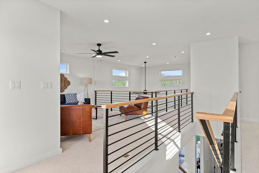 Hallway with light carpet, recessed lighting, and an upstairs landing