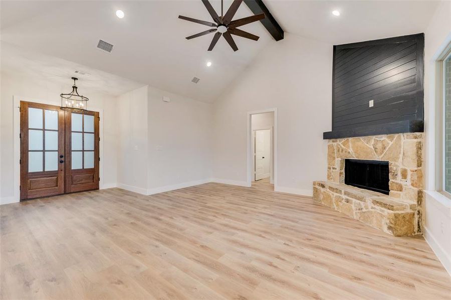 Unfurnished living room with beam ceiling, high vaulted ceiling, light wood-style flooring, recessed lighting, and a ceiling fan Unfurnished living room with beam ceiling, high vaulted ceiling, light wood-style flooring, recessed lighting, and a ceiling fan