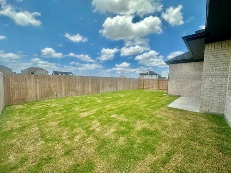 A spacious backyard with fresh green grass and a privacy fence awaits outdoor activities. A spacious backyard with fresh green grass and a privacy fence awaits outdoor activities.