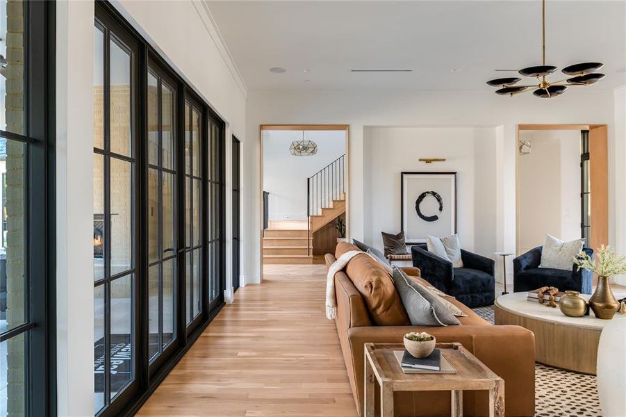 Living room featuring ornamental molding and light hardwood / wood-style flooring