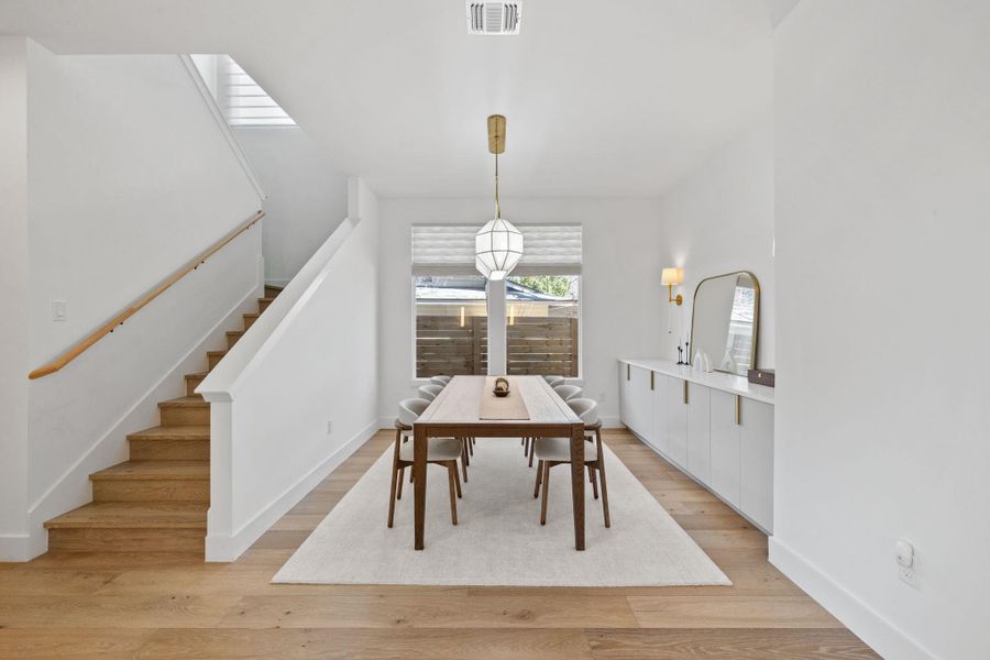 Dining area with stairway and light wood-style flooring