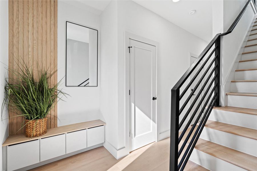 Warm wood textures, modern fluted paneling & a custom built-in bench soften the entry, creating a welcoming first impression. Warm wood textures, modern fluted paneling & a custom built-in bench soften the entry, creating a welcoming first impression.