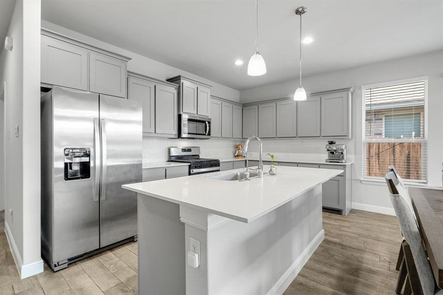 Kitchen featuring gray cabinetry, stainless steel appliances, light wood-style floors, light countertops, and recessed lighting