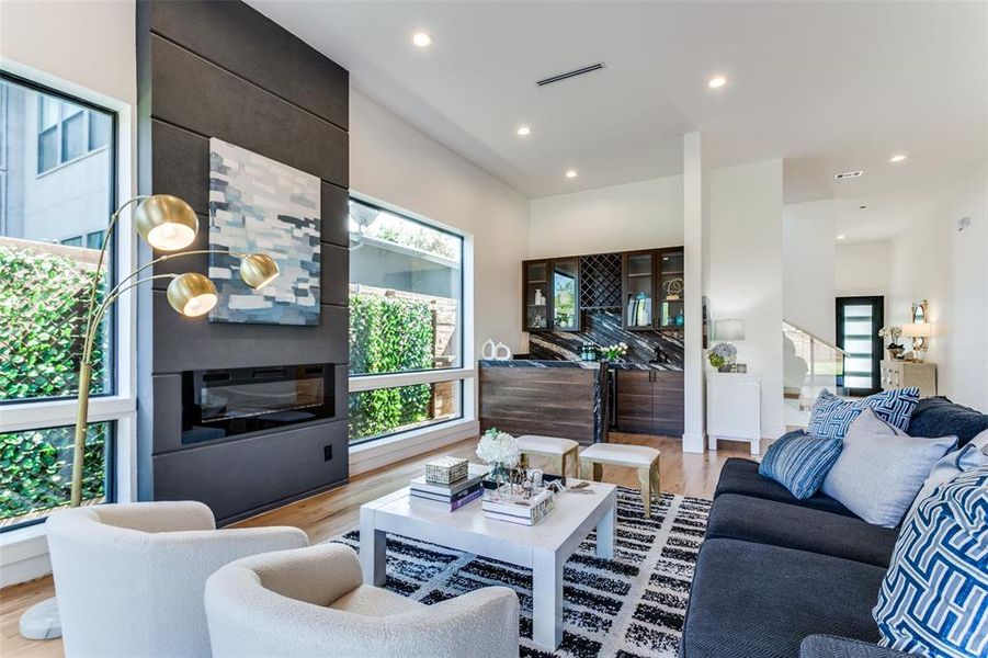 Living room with a fireplace, light hardwood / wood-style floors, and plenty of natural light