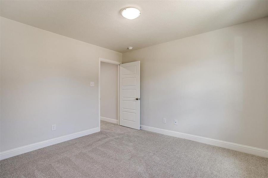Empty room with baseboards and light colored carpet