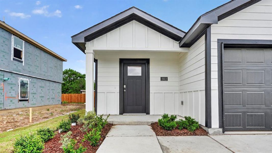 Modern farmhouse-style exterior featuring white horizontal siding and vertical board and batten details