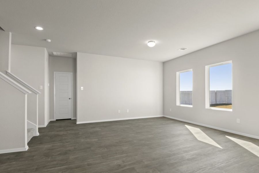 Image of a living room with cream walls, two windows, dark brown flooring and white trim Image of a living room with cream walls, two windows, dark brown flooring and white trim