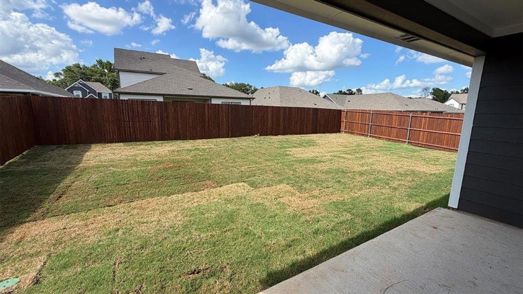 Expansive backyard featuring a new sod lawn and full privacy fencing