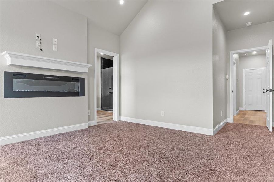 Unfurnished living room featuring light carpet, lofted ceiling, and recessed lighting