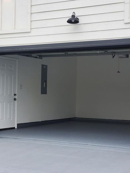garage with a side door to access back patio as well as emergency exit