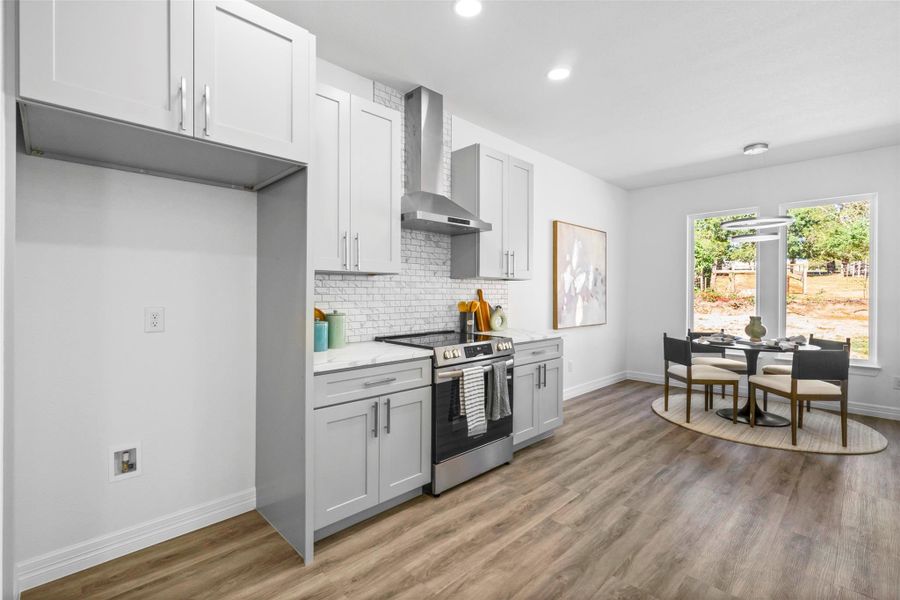Kitchen featuring stainless steel range with electric cooktop, wall chimney range hood, decorative backsplash, dark wood-type flooring, and white cabinets