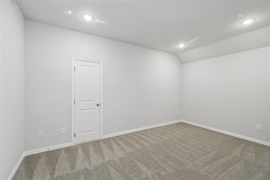 Carpeted spare room with recessed lighting, vaulted ceiling, and baseboards Carpeted spare room with recessed lighting, vaulted ceiling, and baseboards