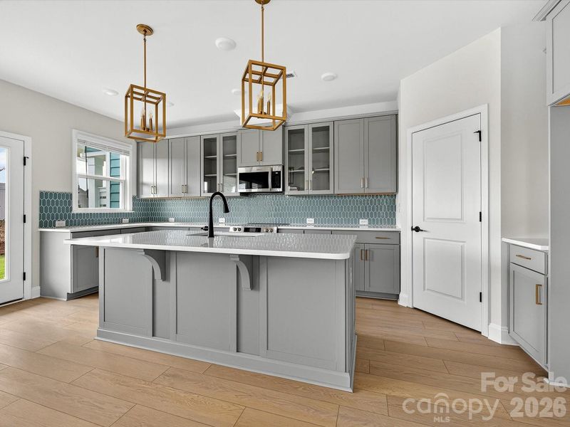 42" cabinets with soft close doors and drawers, quartz countertops, tile backsplash. Frigidaire gallery appliances. Microwave is exhaust vented to the outside. Large pantry with solid shelving