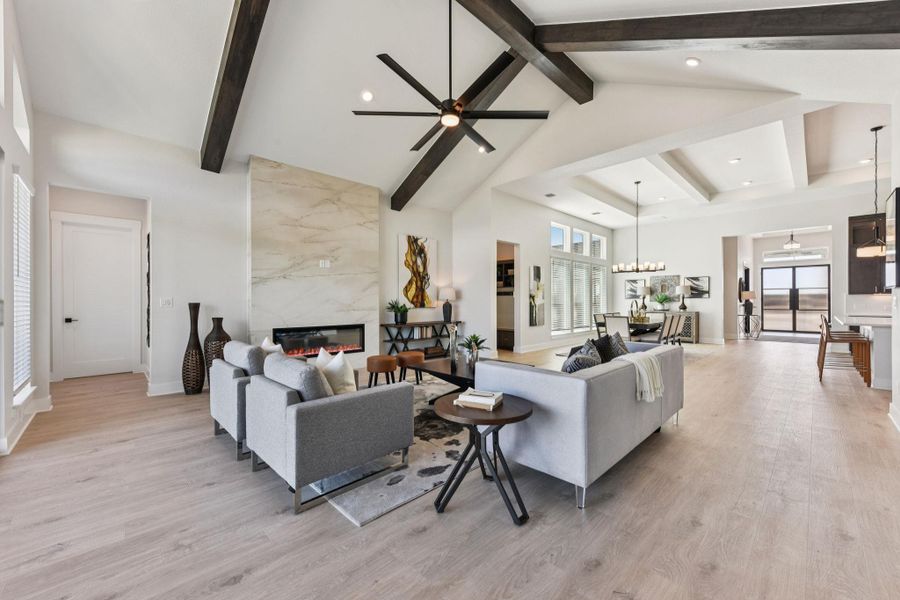 Living room featuring light wood-style floors, a premium fireplace, a ceiling fan, recessed lighting, and vaulted ceiling