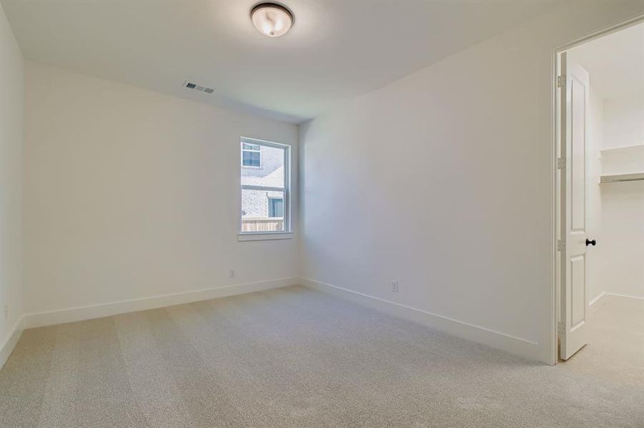 Empty room featuring light carpet and baseboards