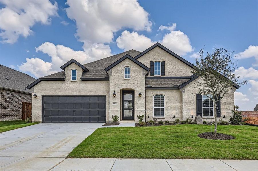 French country inspired facade with a garage and a front lawn