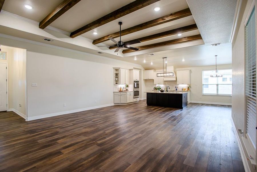 Living area featuring ceiling fan, beamed ceiling, dark wood-style floors, and a chandelier Living area featuring ceiling fan, beamed ceiling, dark wood-style floors, and a chandelier