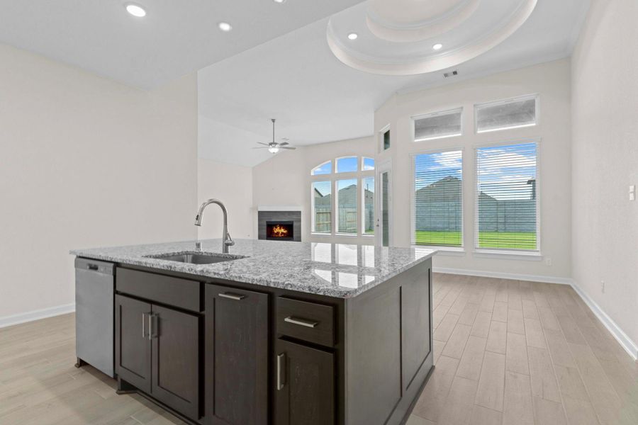 Open-concept view from the kitchen island into the family room, highlighting the seamless flow of the home and perfect space for entertaining.