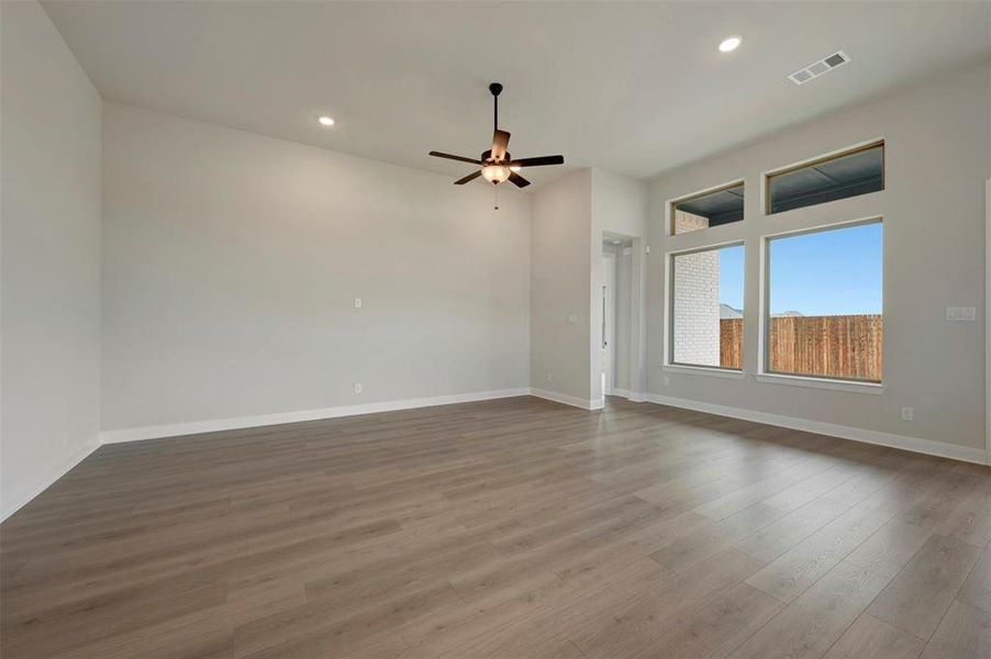 Empty room with a ceiling fan, dark wood-type flooring, and recessed lighting