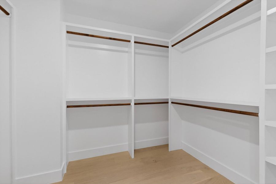 Ample built-in shelving and hanging rods provide organizational ease in this well-appointed closet.
