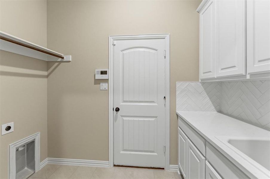 Laundry room featuring electric dryer hookup and baseboards Laundry room featuring electric dryer hookup and baseboards