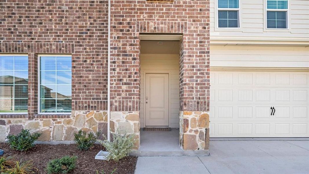 Property entrance with brick siding and a garage