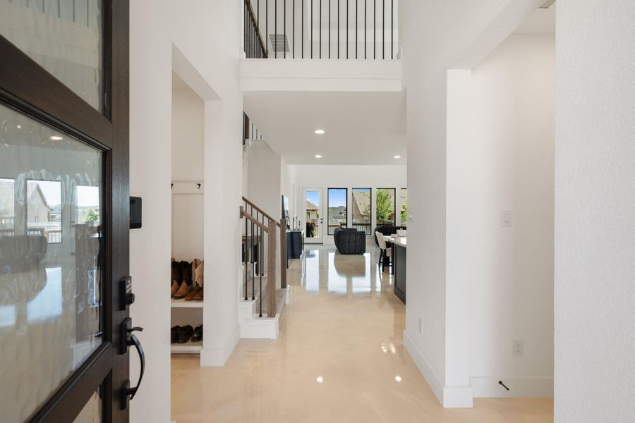 A sun-drenched entry hall welcomes guests with its open layout and view to the modern living spaces beyond. A sun-drenched entry hall welcomes guests with its open layout and view to the modern living spaces beyond.